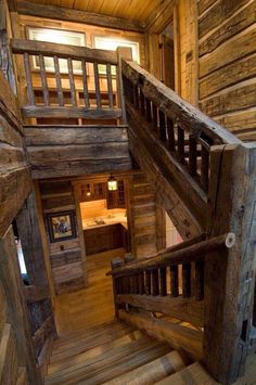 a wooden staircase leading up to the second floor in a log cabin with wood floors and walls