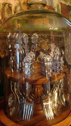 there is a glass jar with silverware in it on top of a wooden table