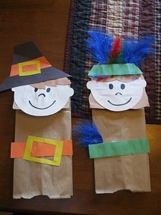 two paper bag puppets with faces on them