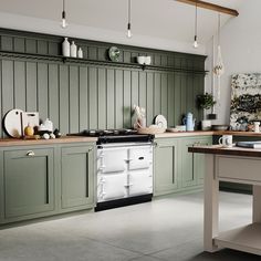 a kitchen with green cabinets and an oven in the center, along with white counter tops