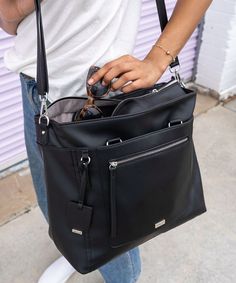 a woman is holding a black purse