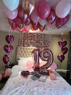 a birthday bed with balloons and streamers in the shape of number 19 on it