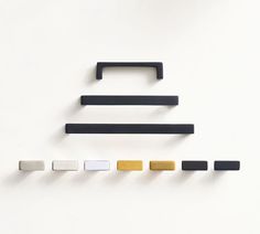 an assortment of different colored handles on a white surface with black and gold trims