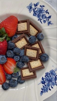 strawberries, blueberries and crackers on a plate