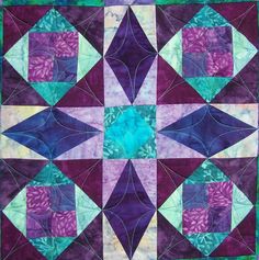 a purple and green quilt with an abstract design