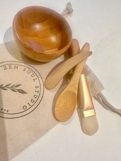 wooden utensils and spoons are sitting on a bag next to a bowl