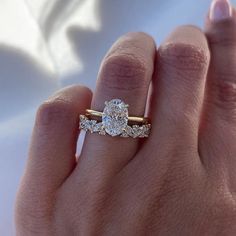 a woman's hand with two engagement rings on it