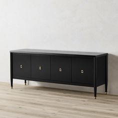 an empty room with a black cabinet and wooden floors