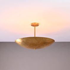 a large brass bowl hanging from a ceiling fixture