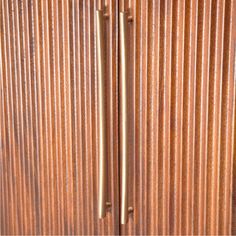 a close up view of a metal door with vertical slats on the doors and handles