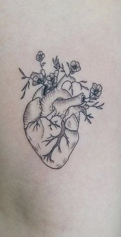 a heart tattoo with flowers growing out of it's side ribcadings