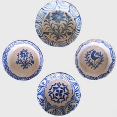 three blue and white plates sitting on top of each other in the shape of flowers