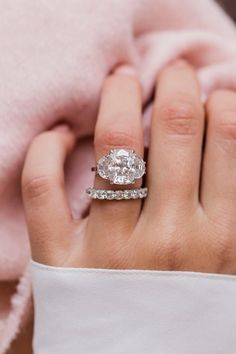 a close up of a person's hand with a diamond ring