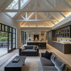 a living room filled with furniture and a fire place in the middle of it's ceiling