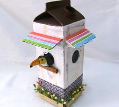 a bird house made out of cardboard with a brown roof