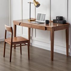 a wooden desk with a laptop on it and a chair in front of the desk