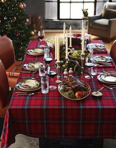 a christmas table setting with candles and plates