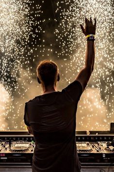 a man standing in front of a sound board with fireworks