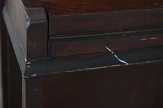 an old wooden desk with peeling paint on the top and one drawer missing from it