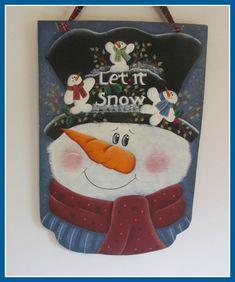 a snowman is hanging on the wall next to a sign that says let it snow