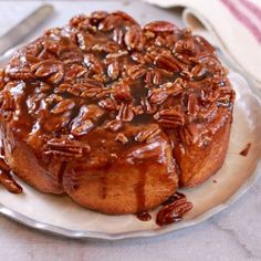 a cake with pecans on top sitting on a plate