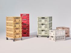 four different colored crates sitting next to each other on top of a white flooring