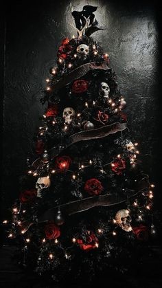 a decorated christmas tree with skulls, roses and lights on it in the dark room