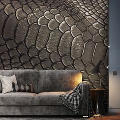 a couch sitting in front of a wall with a large stone pattern on it's side