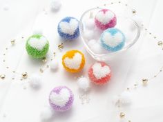 small beads are arranged in the shape of hearts on a white surface with bead garlands