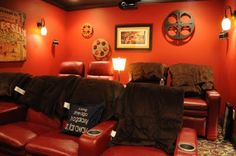 a red room with two recliners and some pictures on the wall behind them