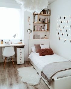 a bedroom with a bed, desk and shelves on the wall next to a window