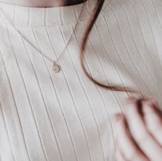 a woman wearing a white shirt and necklace