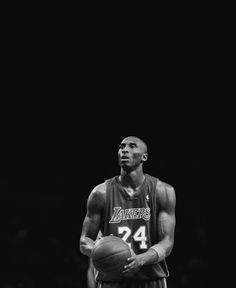 a man holding a basketball in his right hand and wearing a jersey with the number 24 on it