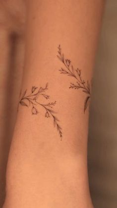 a woman's arm with a small tattoo design on the left side of her wrist