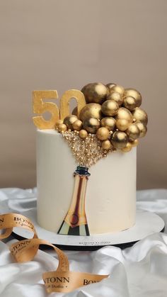 a 50th birthday cake with gold decorations on top