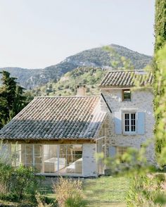 the house is surrounded by greenery and mountains