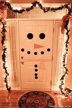 a snowman door decorated with christmas lights and garland on the front entrance to a house