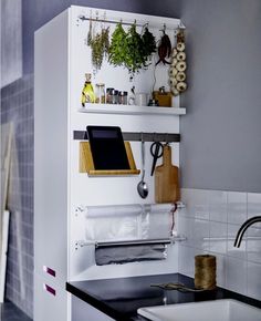 an image of a small space with plants on the shelf and kitchen utensils