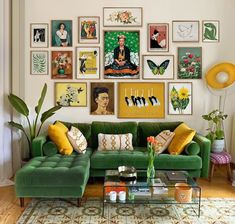 a living room with green couches and pictures on the wall