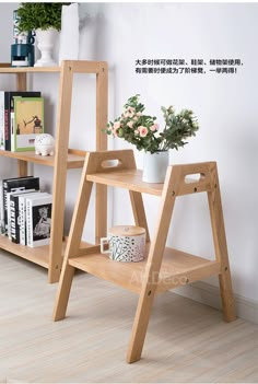 a wooden ladder shelf with flowers and books on it in front of a white wall