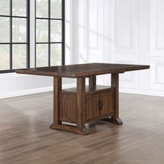 a dining room table with an open cabinet underneath it in front of a large window