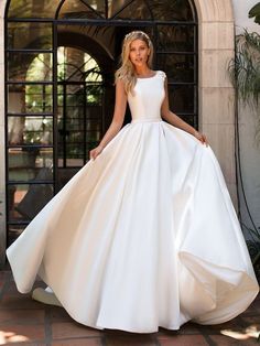 a woman in a white wedding dress posing for the camera