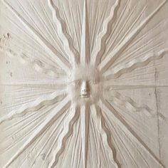 an intricately carved wall panel in the shape of a sun