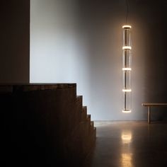 a light that is hanging from the side of a wall next to a wooden bench