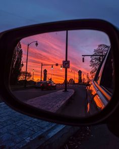 a car's side view mirror reflecting the sunset