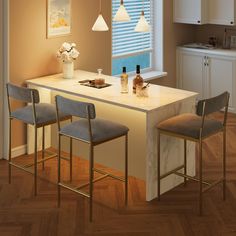 a kitchen island with three stools next to it