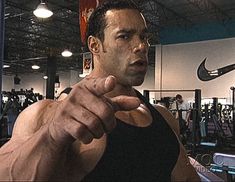 a man pointing at the camera in a gym