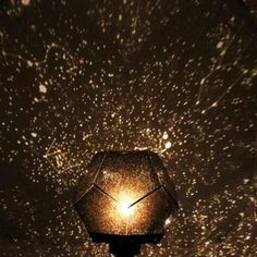 a lamp that is sitting on top of a wooden table with stars in the sky above it