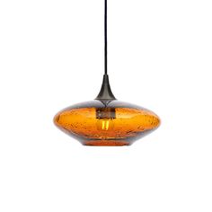 an orange glass light hanging from a black cord