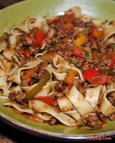 a green plate filled with pasta and meat